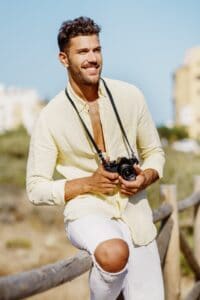 Smiling man photographing in a coastal area